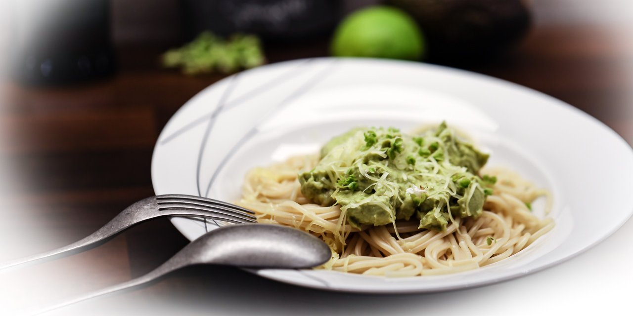 fertig angerichtete Portion der Avocado-Basilikum-Limetten-Nudeln mit Parmesan bestreut