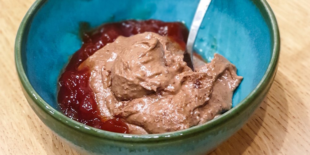 © Sabine Nußbaumer Schüssel mit leckerer selbstgemachter Schoko-Nusscreme mit einem Klecks Marmelade