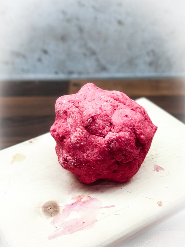 rosa gnocchi-teigkugel auf dem holzbrett