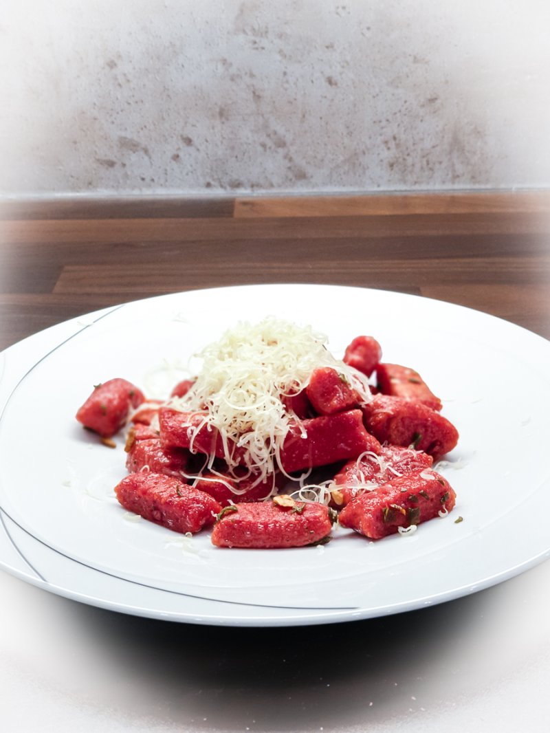 teller mit rote-rüben-gnocchi, salbeibutter und frisch geriebenem käse