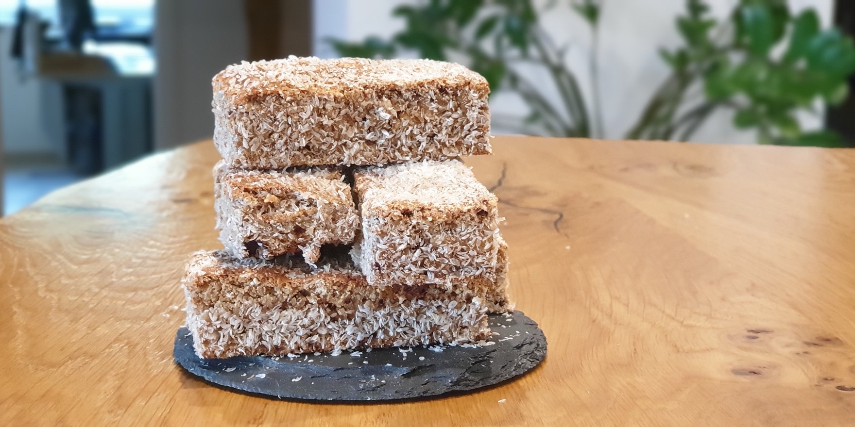 stapel selbstgemachter haferflockenriegel mit kokosraspeln auf schieferplatte