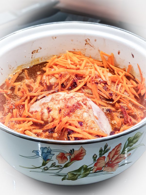 karottenstifte und paprika auf dem hühnerfleisch im topf