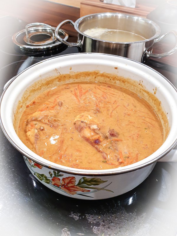 karotten-hühner-topf mit cremiger rahmsauce auf dem herd