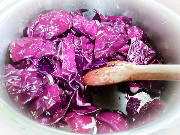 Rotkraut und Zwiebel werden mit Gewürzen im Topf angebraten