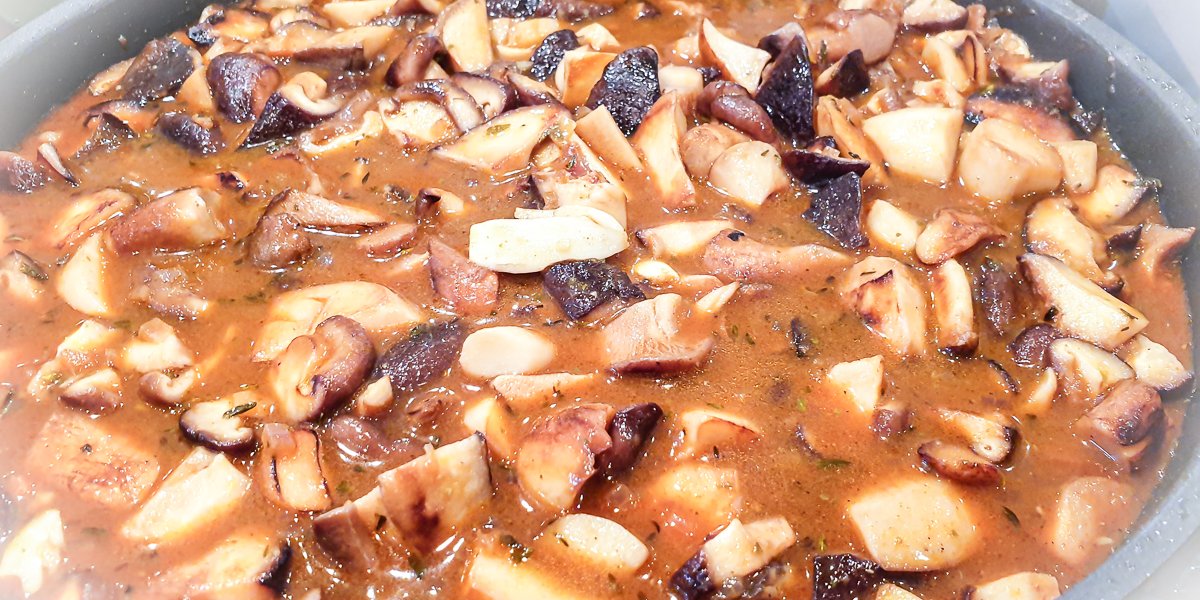 schwammerlgulasch mit verschiedenen pilzen köchelt in der pfanne
