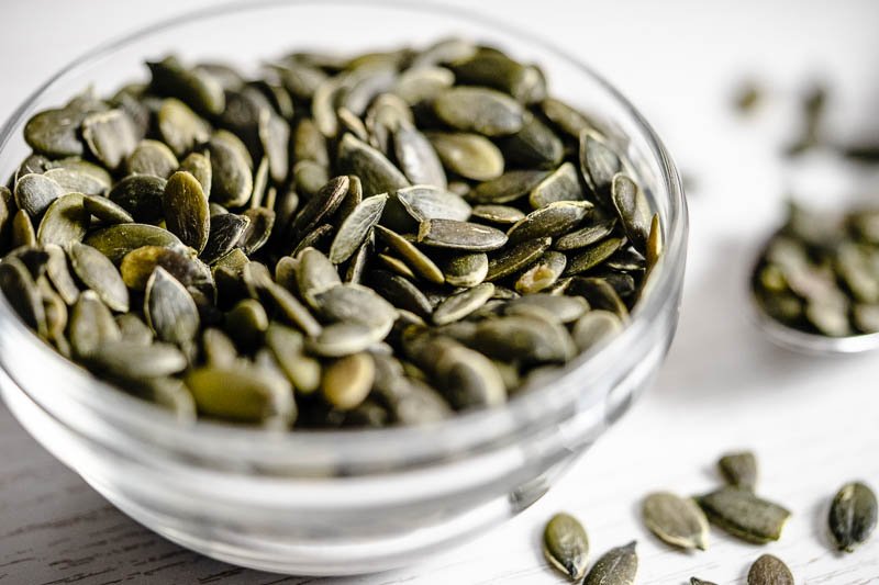 Superfood Kürbiskerne ein Glasschälchen voller Kürbiskerne