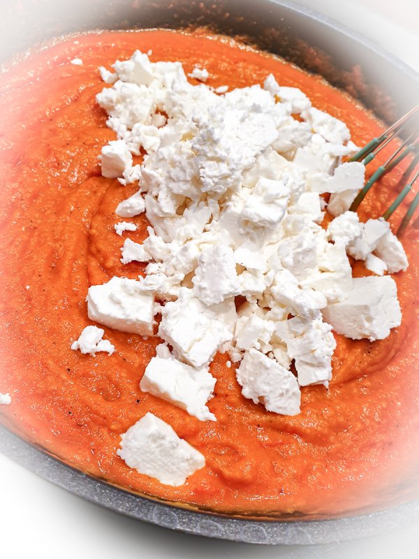 Rezept Tomatenfetasauße Tomatensauce köchelt vor sich hin und der Feta wird gerade eingebröckelt und untergerührt